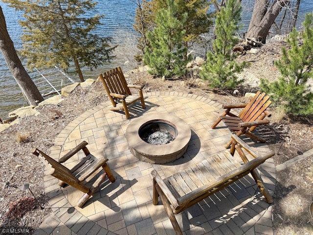 view of patio / terrace with a fire pit and a water view