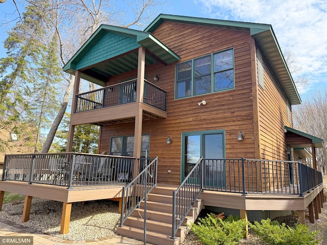 back of property with a deck and a balcony