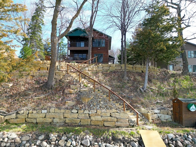 view of yard with stairway and a balcony
