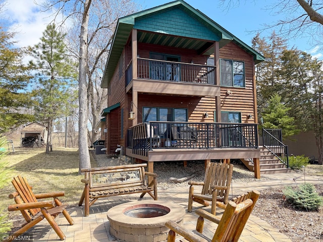 rear view of house featuring a fire pit, a balcony, a deck, a patio area, and stairway
