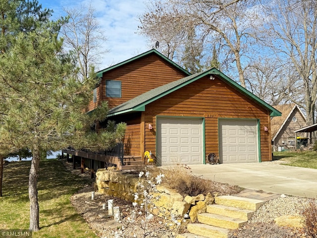 chalet / cabin featuring a garage and driveway