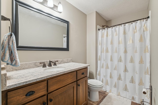 bathroom with vanity, a textured ceiling, and toilet