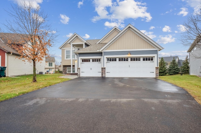 craftsman-style house featuring a garage and a front lawn