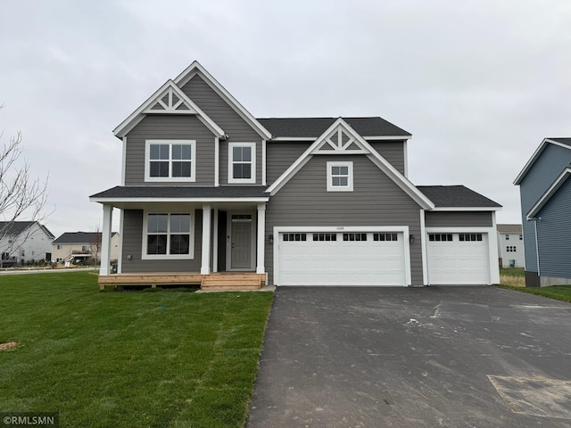 craftsman inspired home featuring a garage and a front lawn