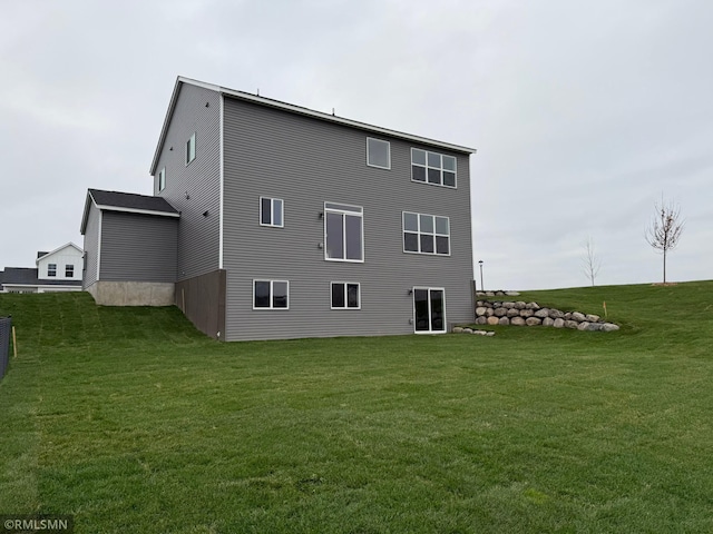 rear view of house featuring a lawn