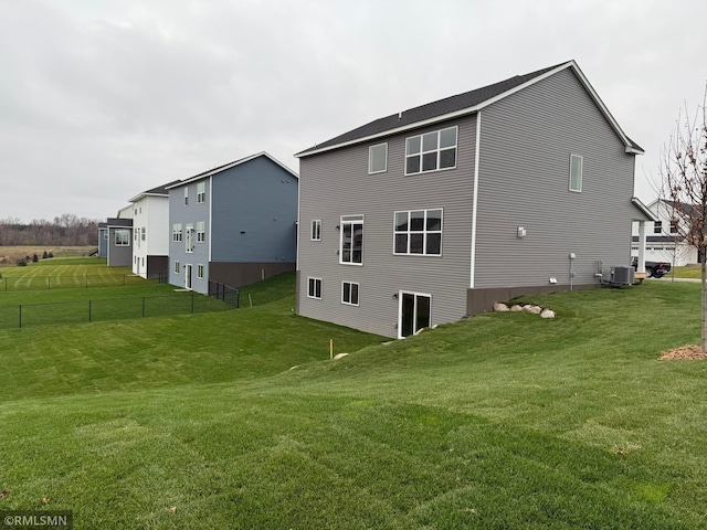 rear view of property with a yard and central AC