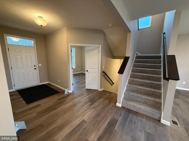 foyer entrance with dark hardwood / wood-style flooring and a textured ceiling