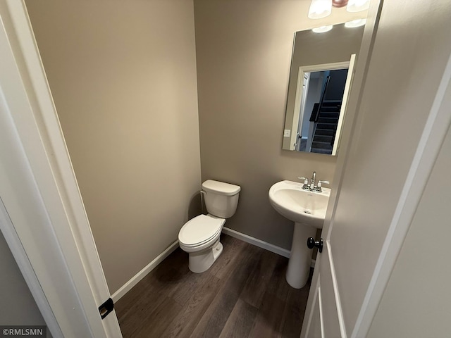 bathroom with hardwood / wood-style flooring and toilet