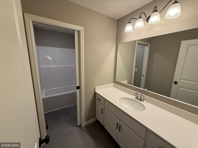 bathroom featuring vanity, a bath, and a textured ceiling