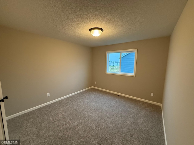 spare room featuring carpet and a textured ceiling