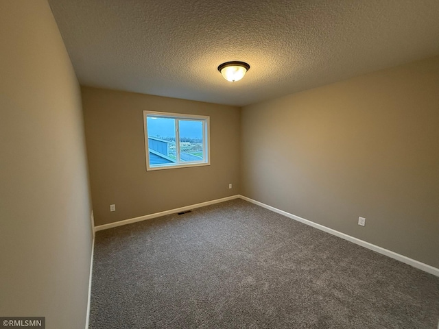 empty room featuring carpet flooring and a textured ceiling