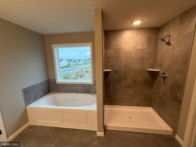 bathroom with a textured ceiling, tile patterned floors, and independent shower and bath