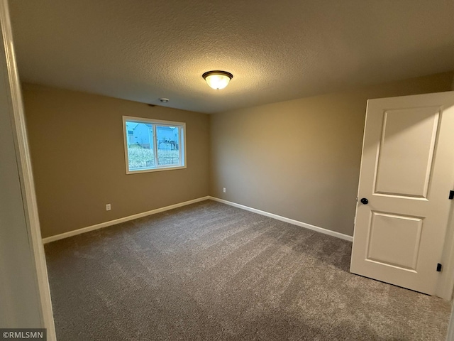 empty room with a textured ceiling and carpet floors