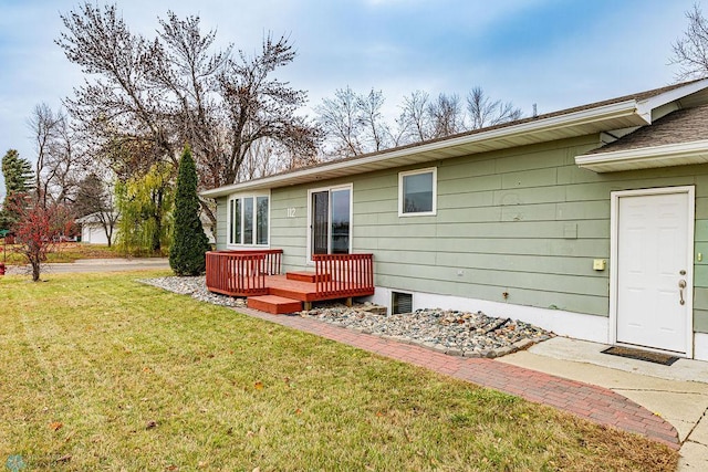 rear view of property featuring a lawn and a deck