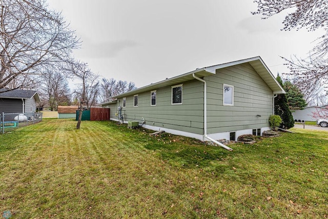 view of home's exterior featuring a lawn and central AC