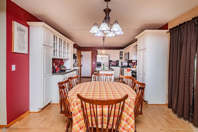 dining room with a chandelier and light hardwood / wood-style flooring