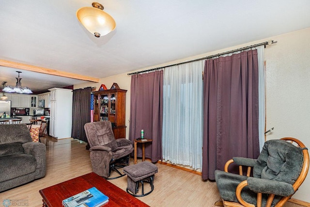 living room with light wood-type flooring and a notable chandelier