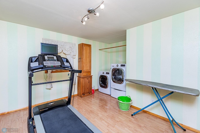 exercise area with light wood-type flooring and washer and clothes dryer