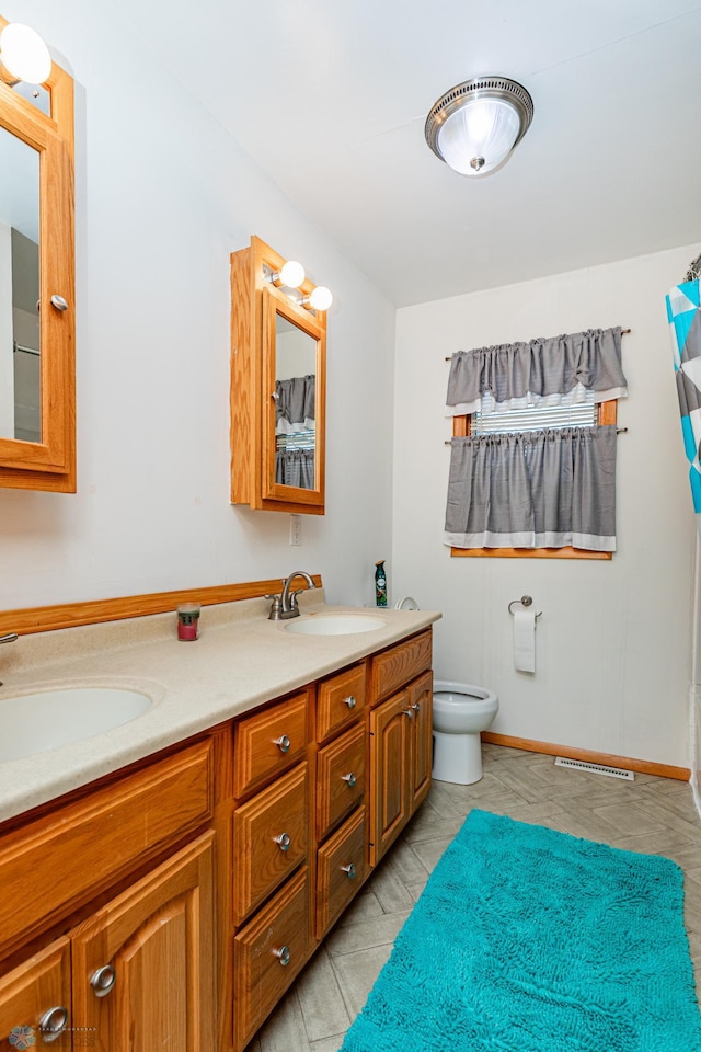 bathroom featuring tile patterned flooring, vanity, and toilet