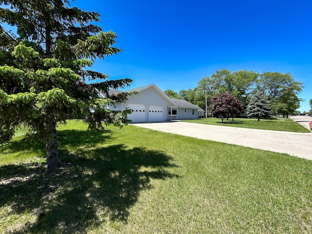 view of side of property with a garage and a lawn