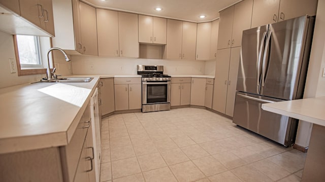 kitchen featuring stainless steel appliances, cream cabinets, and sink