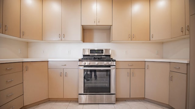 kitchen with light tile patterned flooring and stainless steel gas range