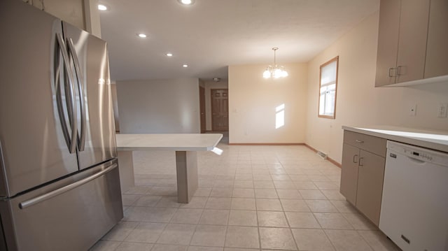 kitchen featuring light tile patterned flooring, decorative light fixtures, stainless steel fridge, a chandelier, and white dishwasher