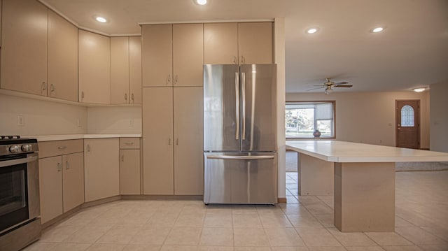 kitchen featuring stainless steel appliances, light tile patterned flooring, a kitchen island, and ceiling fan