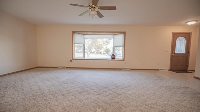 unfurnished living room featuring light colored carpet and ceiling fan