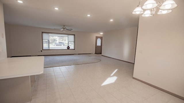 unfurnished living room featuring ceiling fan with notable chandelier