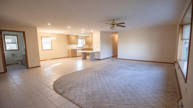 unfurnished living room with light tile patterned floors and ceiling fan with notable chandelier