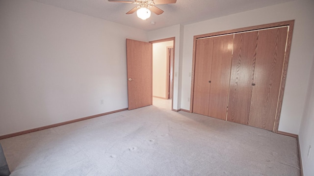 unfurnished bedroom featuring light carpet, ceiling fan, and a closet