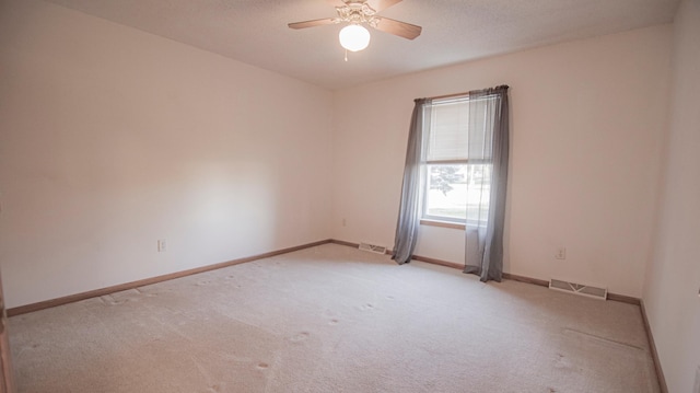 carpeted spare room featuring a textured ceiling and ceiling fan