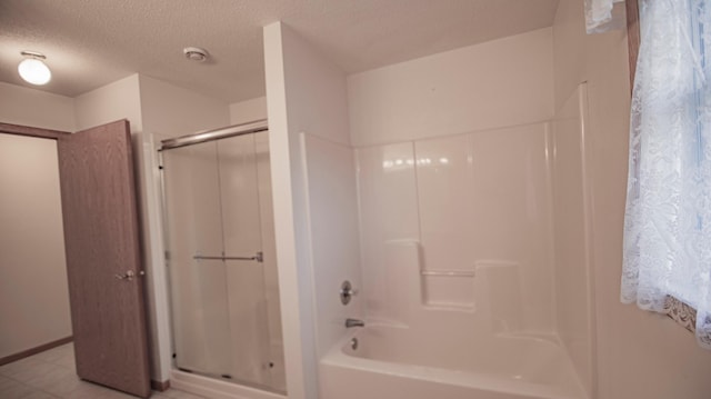 bathroom with shower with separate bathtub and a textured ceiling