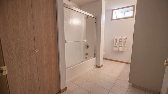 bathroom with toilet, tile patterned flooring, and combined bath / shower with glass door