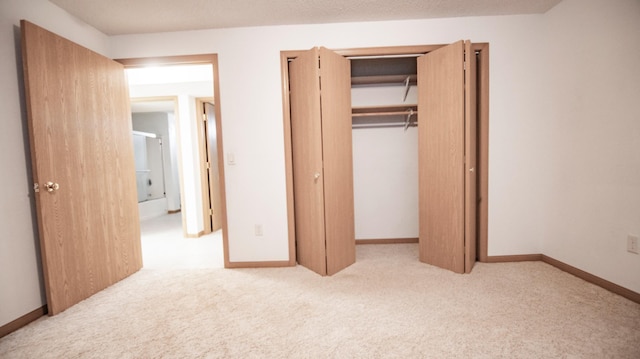 unfurnished bedroom featuring light carpet and a closet