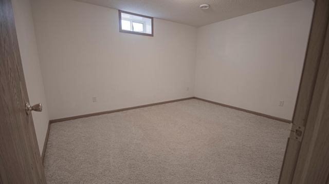 spare room with light colored carpet and a textured ceiling