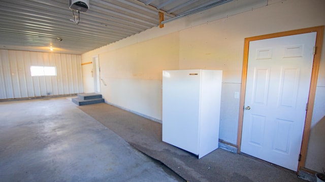 garage with a garage door opener and white fridge