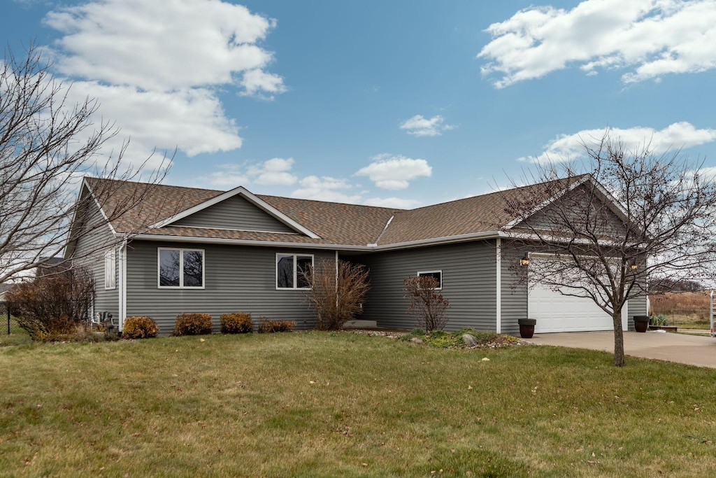 ranch-style house featuring a front lawn and a garage