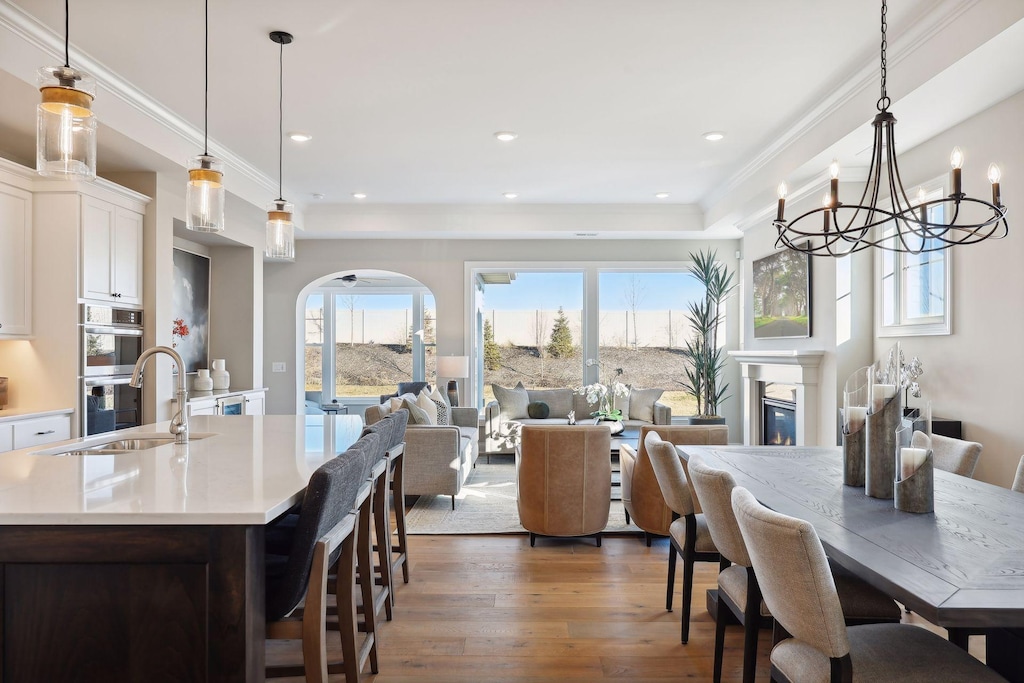 dining space featuring dark hardwood / wood-style floors, ornamental molding, and sink