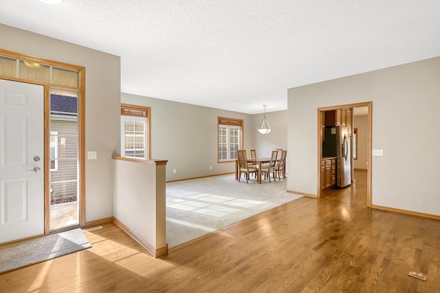 entryway with light wood-type flooring and a textured ceiling