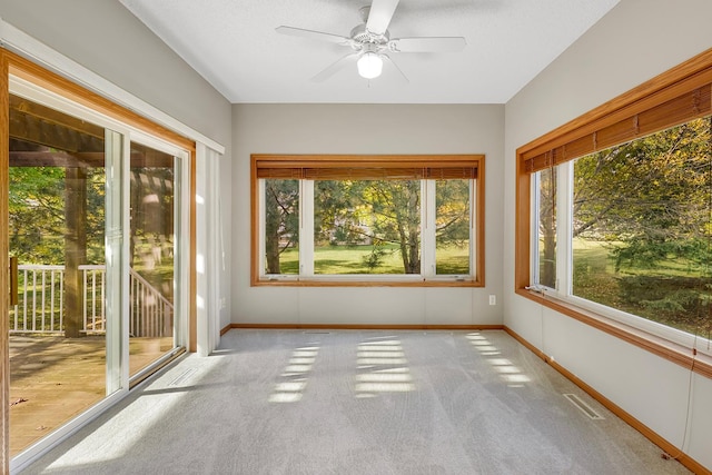 unfurnished sunroom with ceiling fan