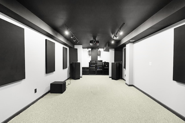 home theater with carpet floors and rail lighting