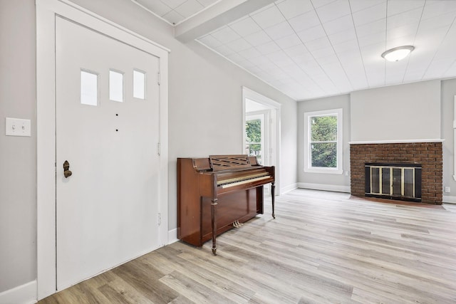 foyer entrance with a fireplace and light wood-type flooring