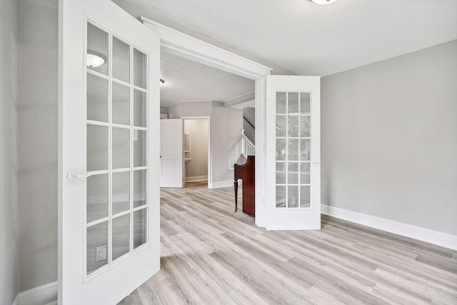 unfurnished room featuring stairway, wood finished floors, and baseboards