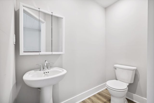 bathroom featuring toilet, baseboards, and wood finished floors