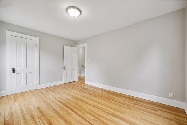 spare room featuring baseboards and hardwood / wood-style floors