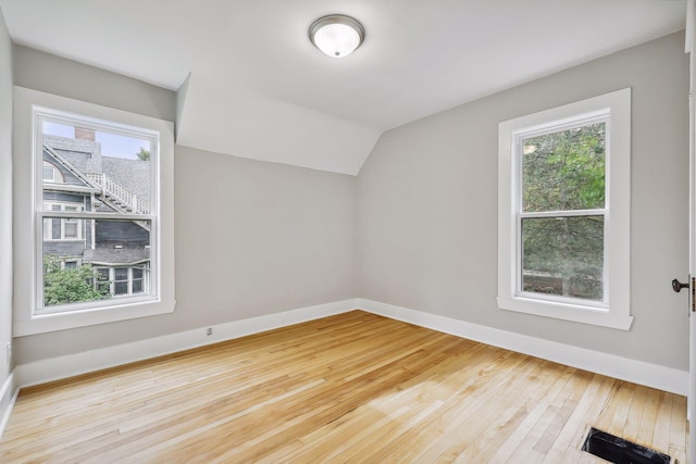 bonus room with baseboards, vaulted ceiling, and hardwood / wood-style floors