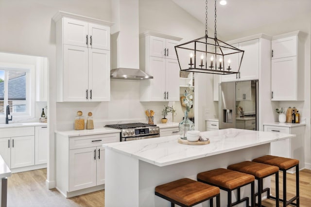 kitchen featuring white cabinets, stainless steel appliances, and wall chimney exhaust hood