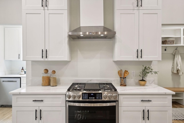 kitchen featuring white cabinets, stainless steel appliances, and wall chimney range hood